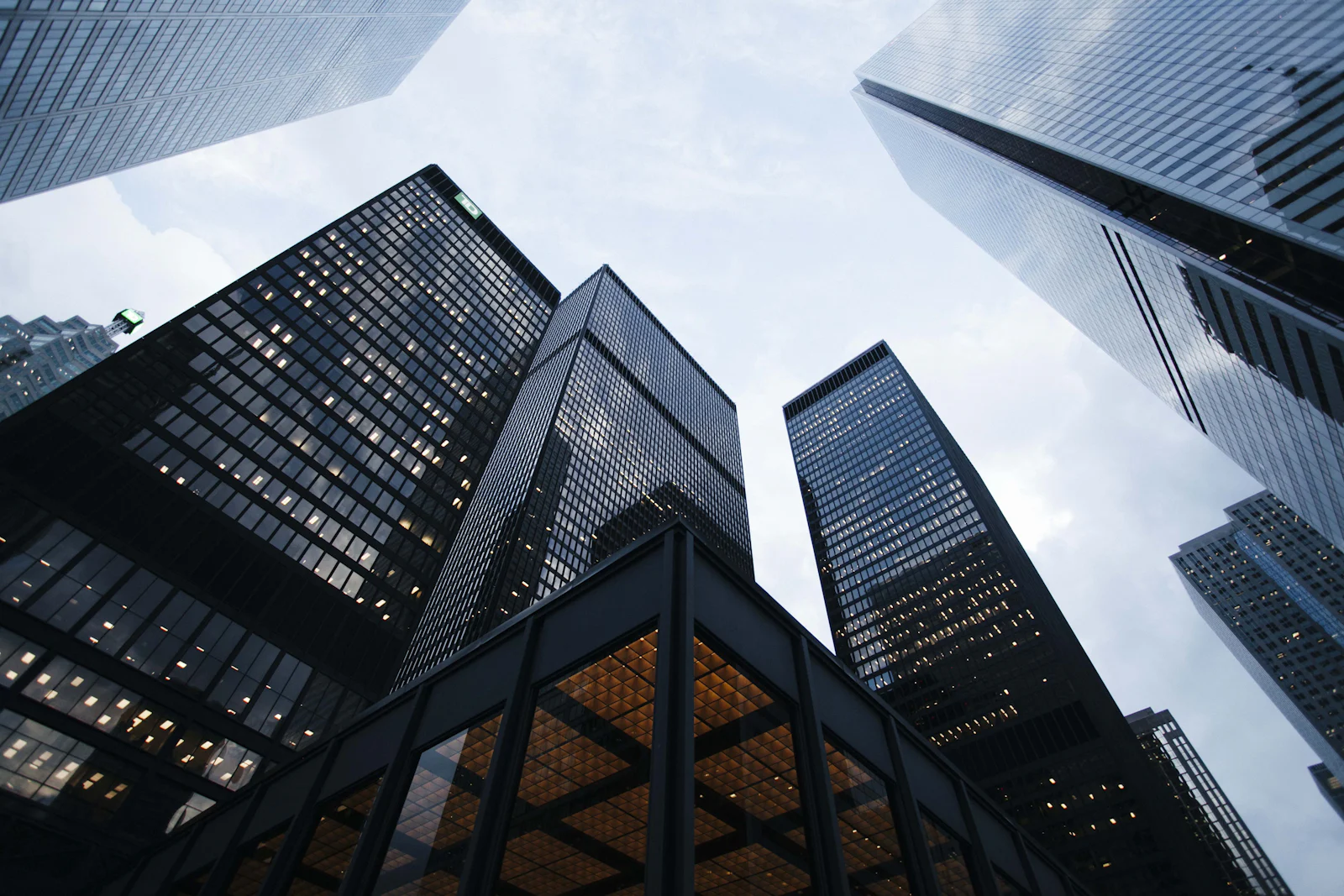 Looking up at glass skyscrapers against a bright sky