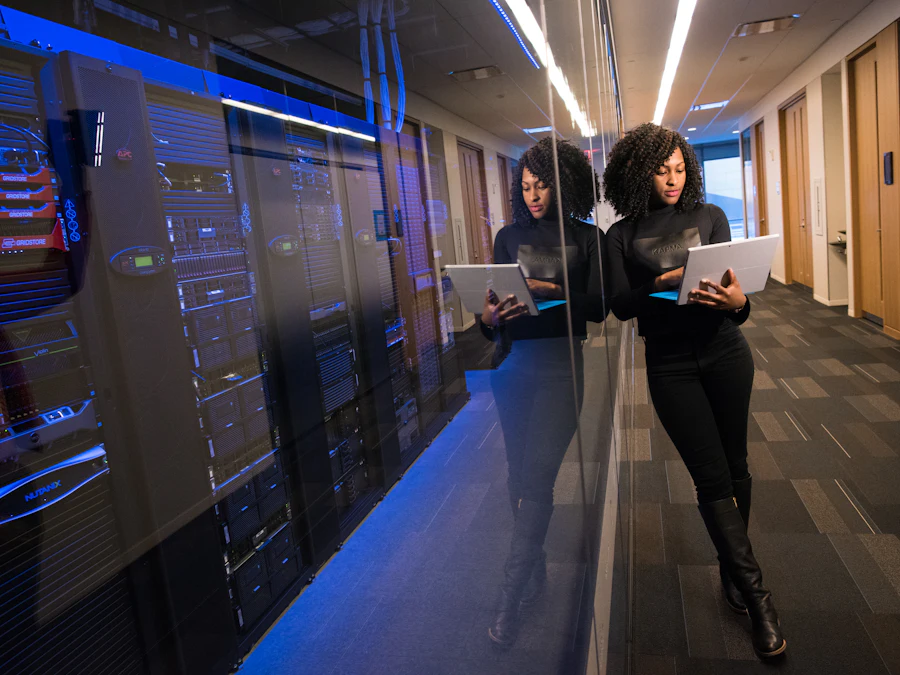 Engineer with a laptop beside server racks in a data center